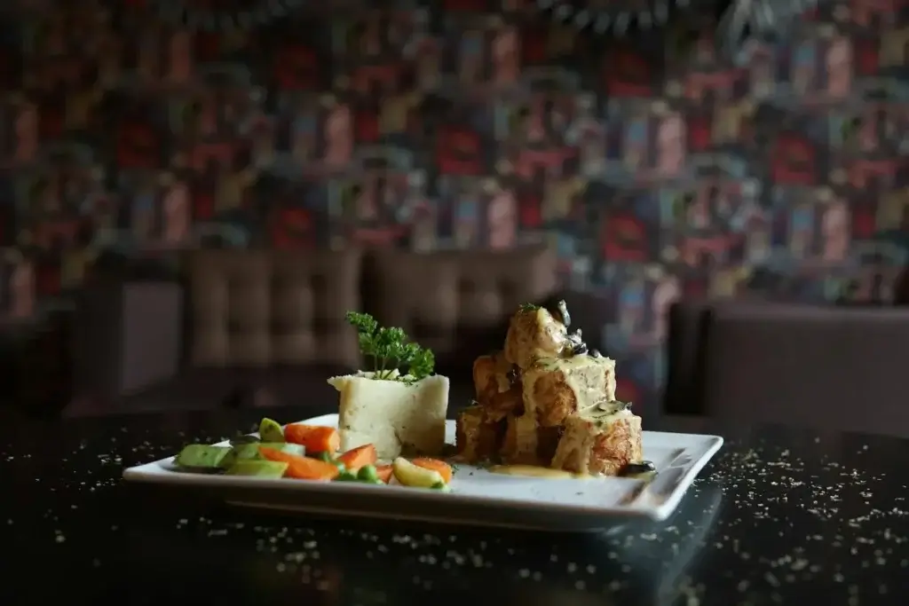 Un delicioso plato gourmet compuesto por carne asada y verduras de colores, presentado de forma exquisita.